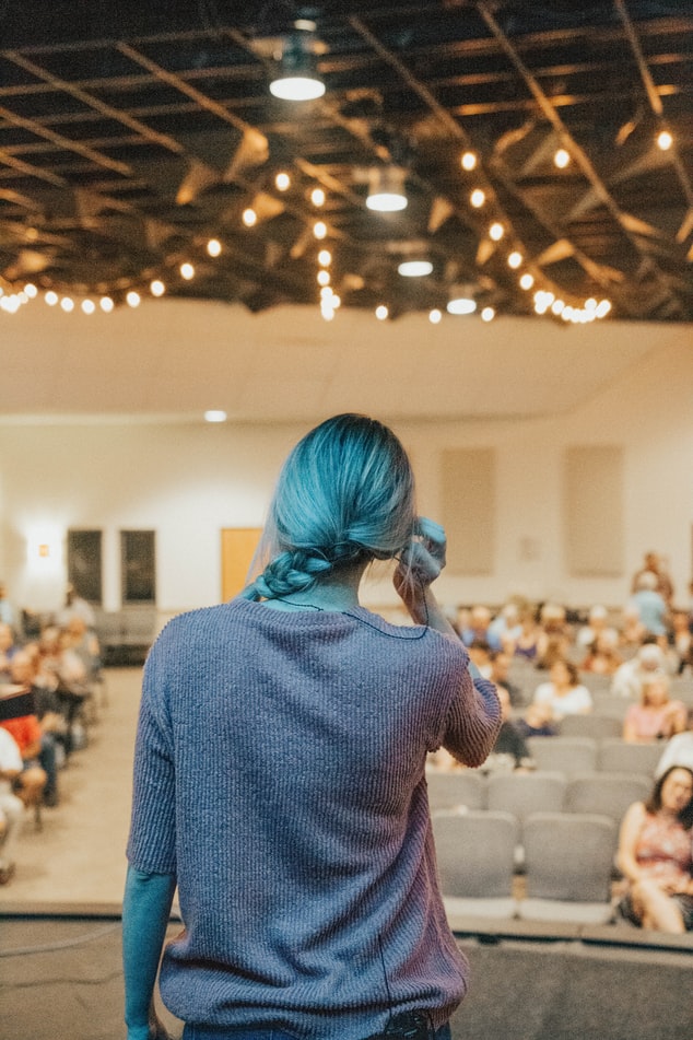 Woman giving a speech in front of a crowd.