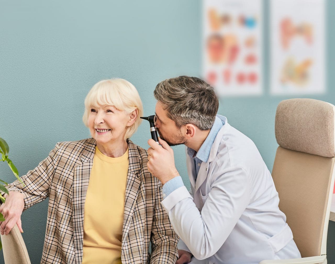 Older woman getting her ears checked by a doctor.