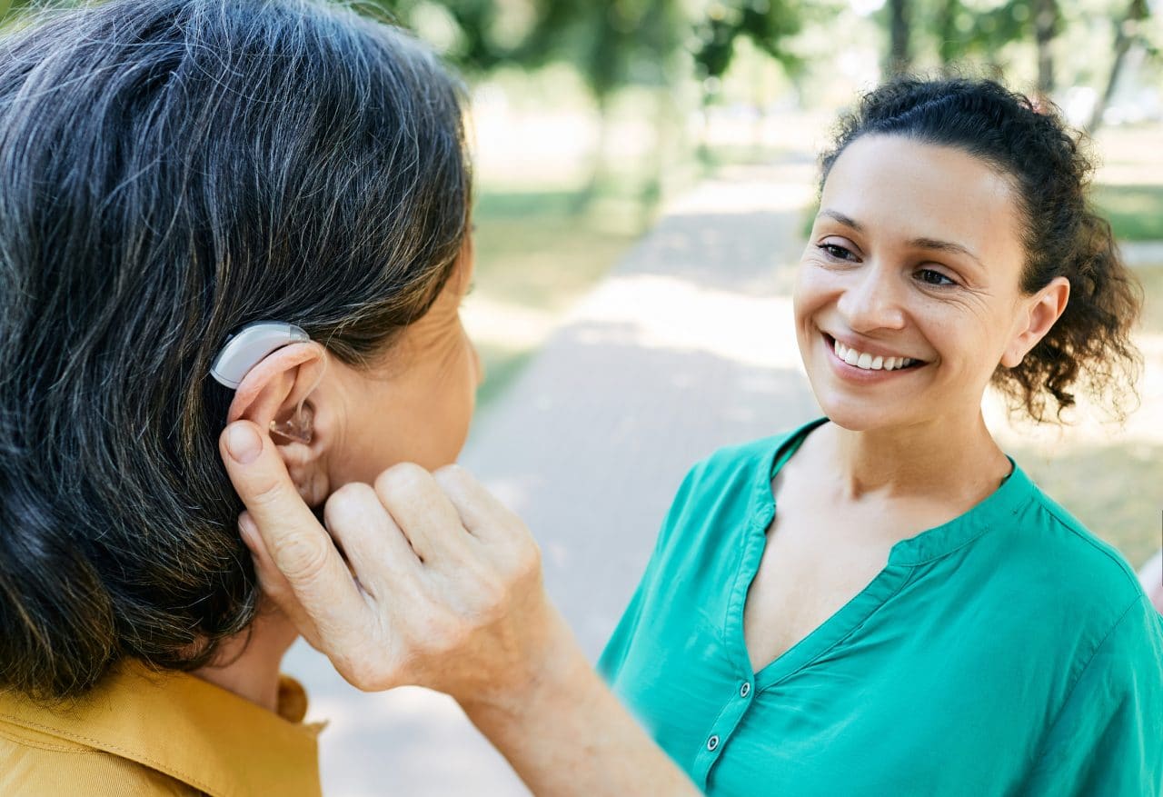 Woman with hearing aid chatting with her friend.
