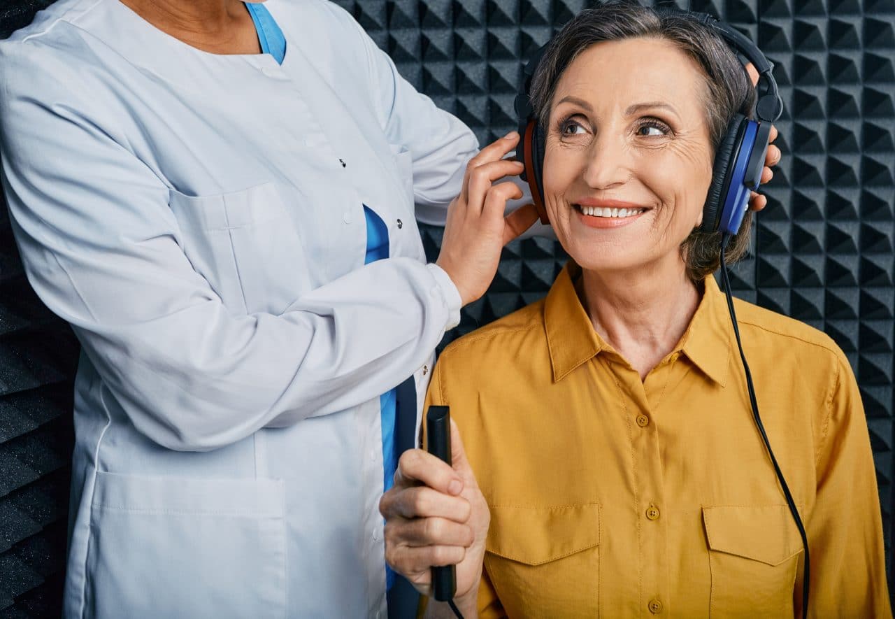 A woman getting a hearing test at an audiologist's office.