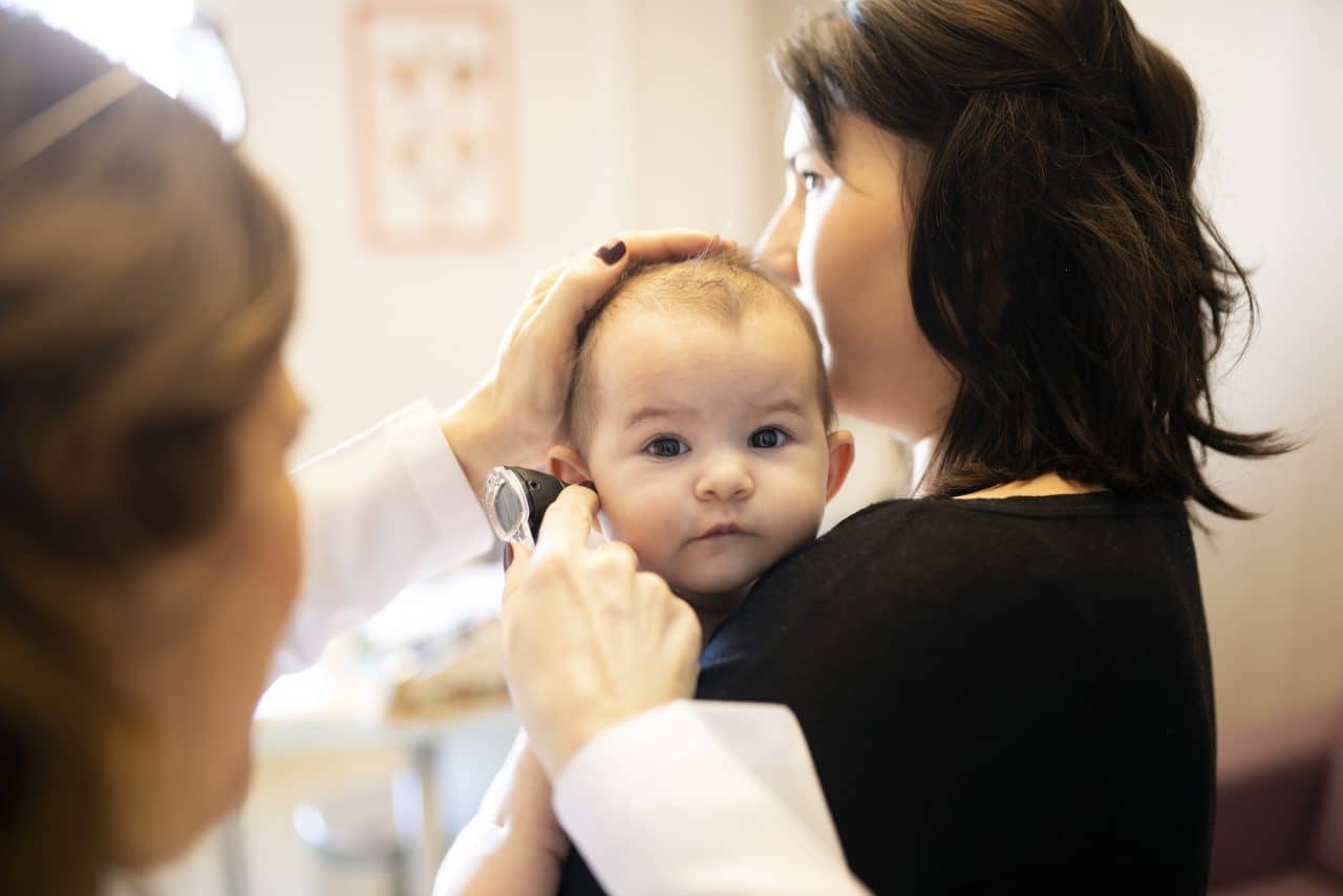 An audiologist examining a baby's ear.