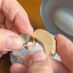 Close up of woman changing her hearing aid battery.