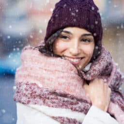 Woman wrapped in a warm scarf in the snow