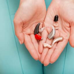 Woman holding a few hearing aids