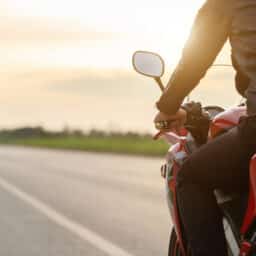Rear View Of Man Riding Motorcycle On Road