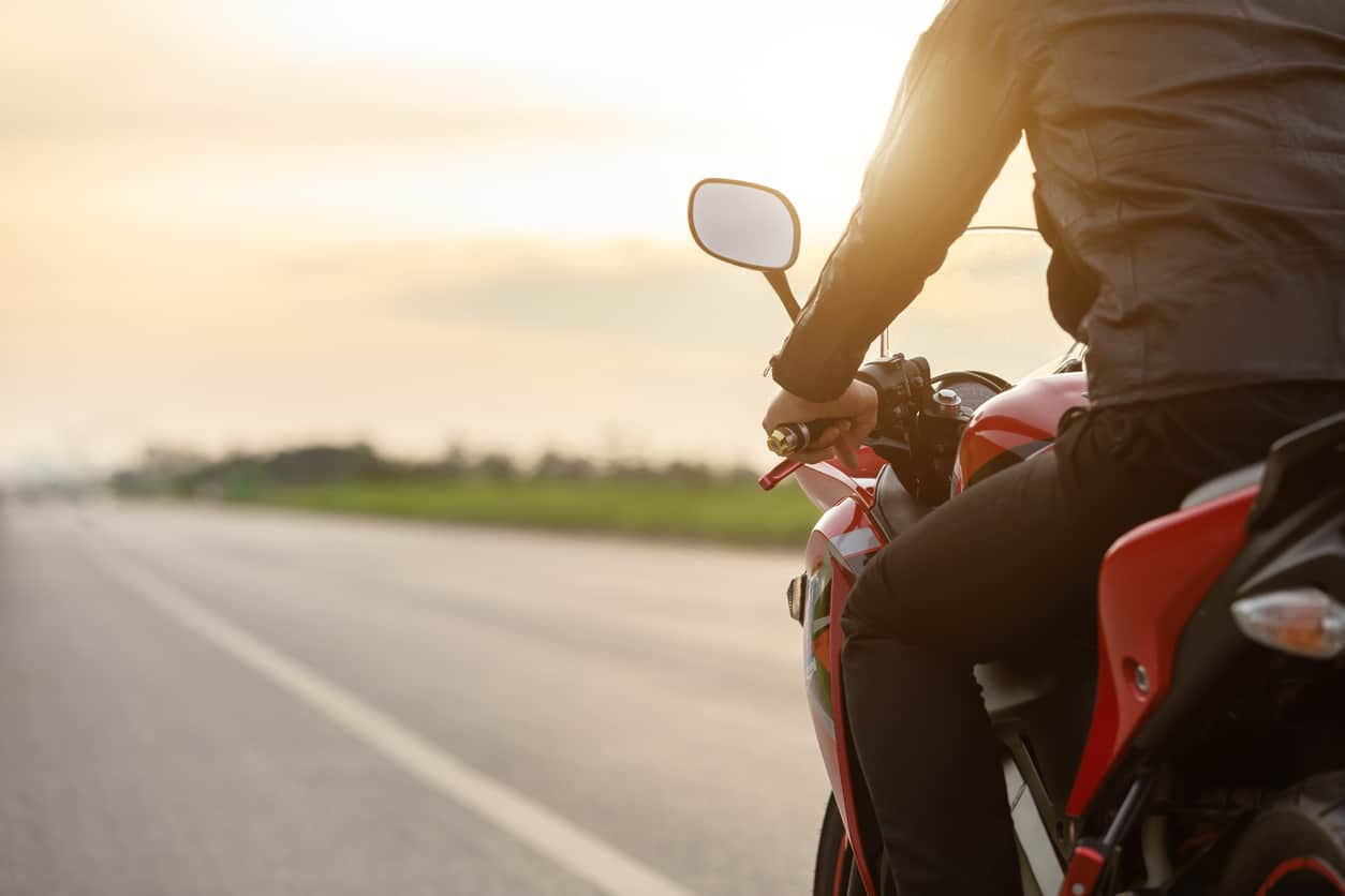 Rear View Of Man Riding Motorcycle On Road